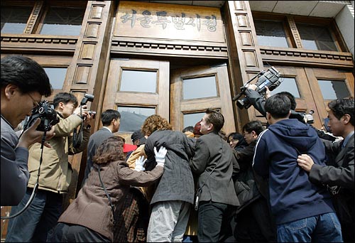 기자회견을 마친 지역주민들이 서울시장 면담을 요구하며 정문으로 들어가려하자 시청 관계자들이 이를 저지하고 있다. 